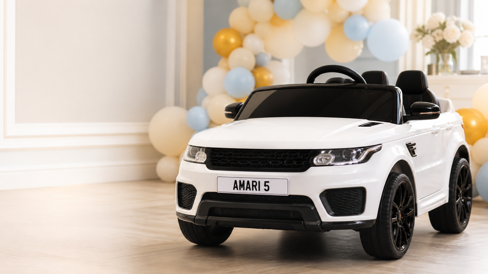 A white children’s ride-on car with a personalised AMARI 5 number plate at a birthday celebration