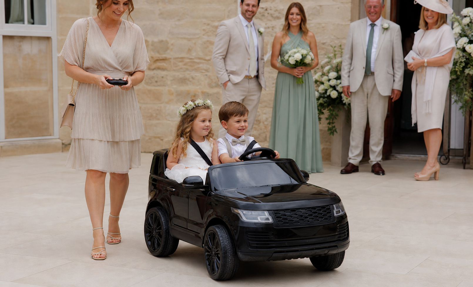 Young guests with a black ride-on car at a wedding